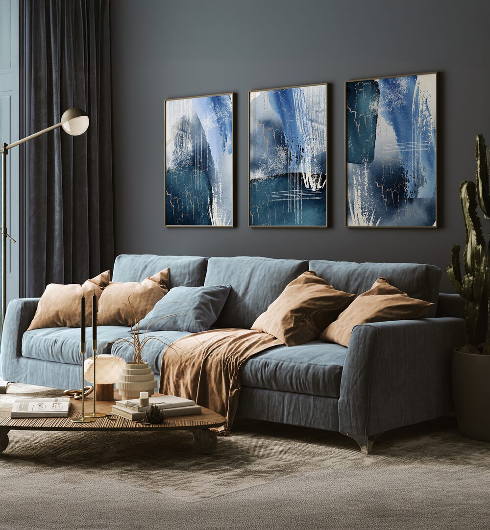 Elegant BLUE LAGOON SET, SET OF 3 PAINTINGS enhancing a stylish living room with serene lagoon-inspired art.