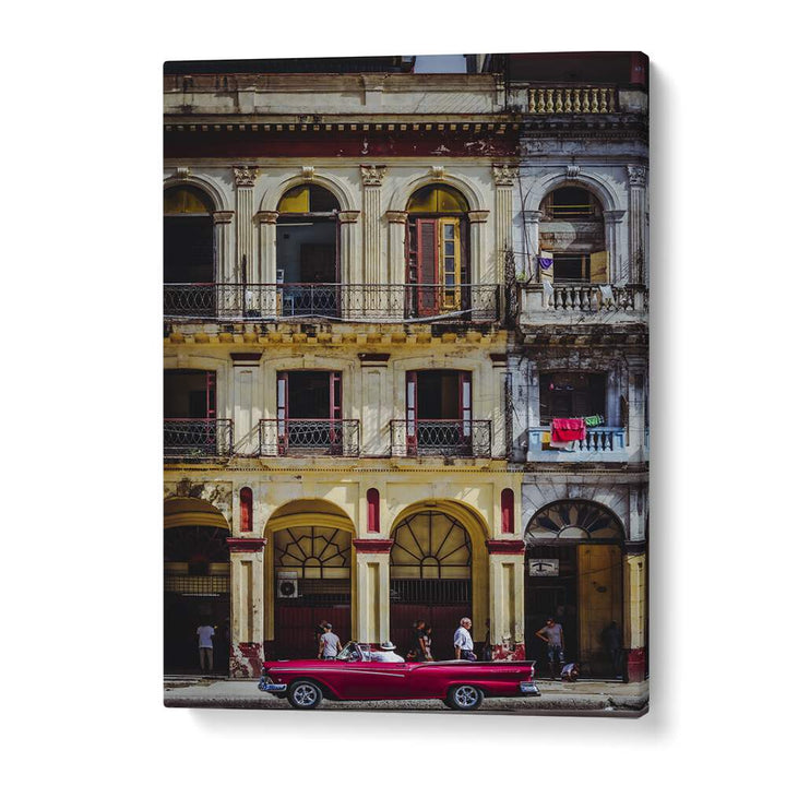 Vibrant red car parked on a bustling Habana street, capturing the essence of Cuban life in photography prints.