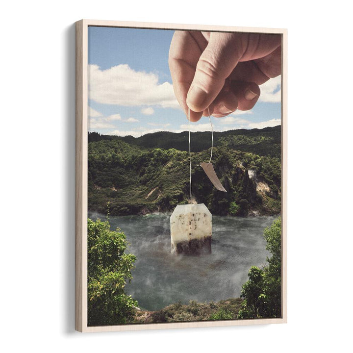 Hand holding a teabag above a tranquil lake in the "LAKE AFTERNOON TEA , SURREAL ART PRINTS" by Vertigo Artography.