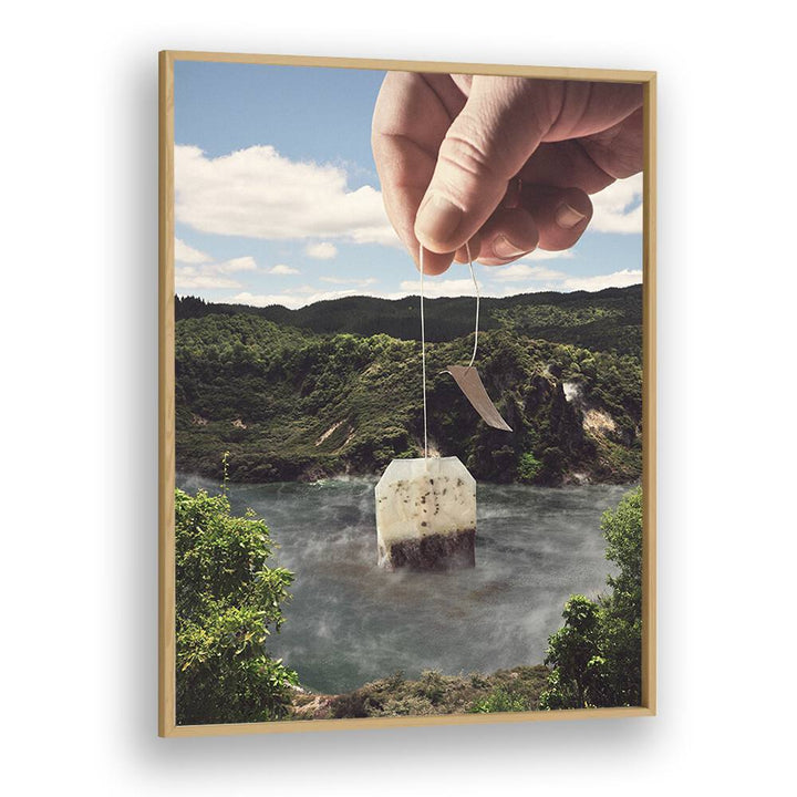 Hand holding a teabag above a serene lake, featuring "Lake Afternoon Tea, Surreal Art Prints" by Vertigo Artography.