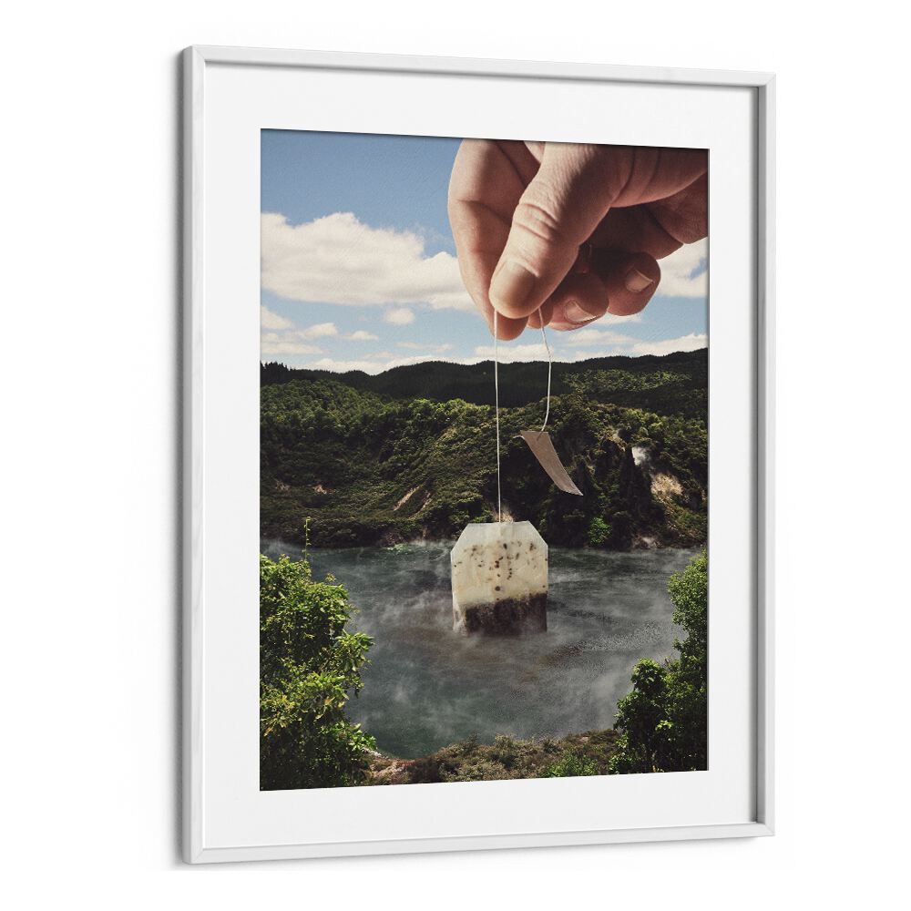 Hand holding a teabag over a serene lake in the LAKE AFTERNOON TEA, SURREAL ART PRINTS by Vertigo Artography.