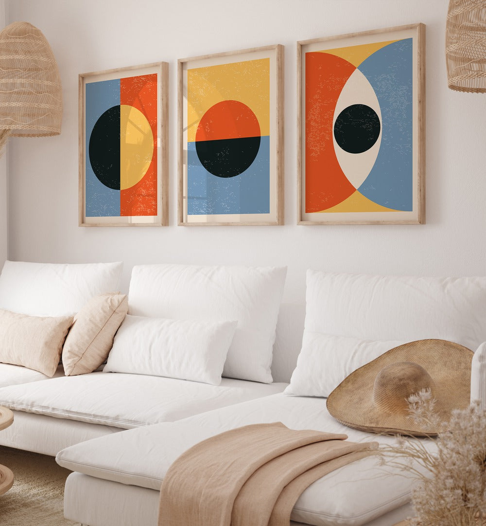 Modern living room featuring the MINIMAL ABSTRACT SHAPES SET, SET OF 3 PAINTINGS beautifully displayed on the wall.