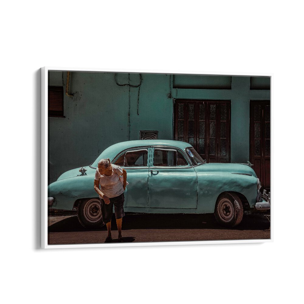 A man interacts with an iconic vintage car in vibrant street scenes, featured in PASSING STREET, PHOTOGRAPHY PRINTS.
