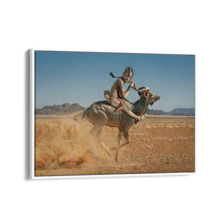 EASY RIDER, PHOTOGRAPHY PRINTS showcase a child riding a goat through stunning desert landscapes, capturing wildlife's essence.