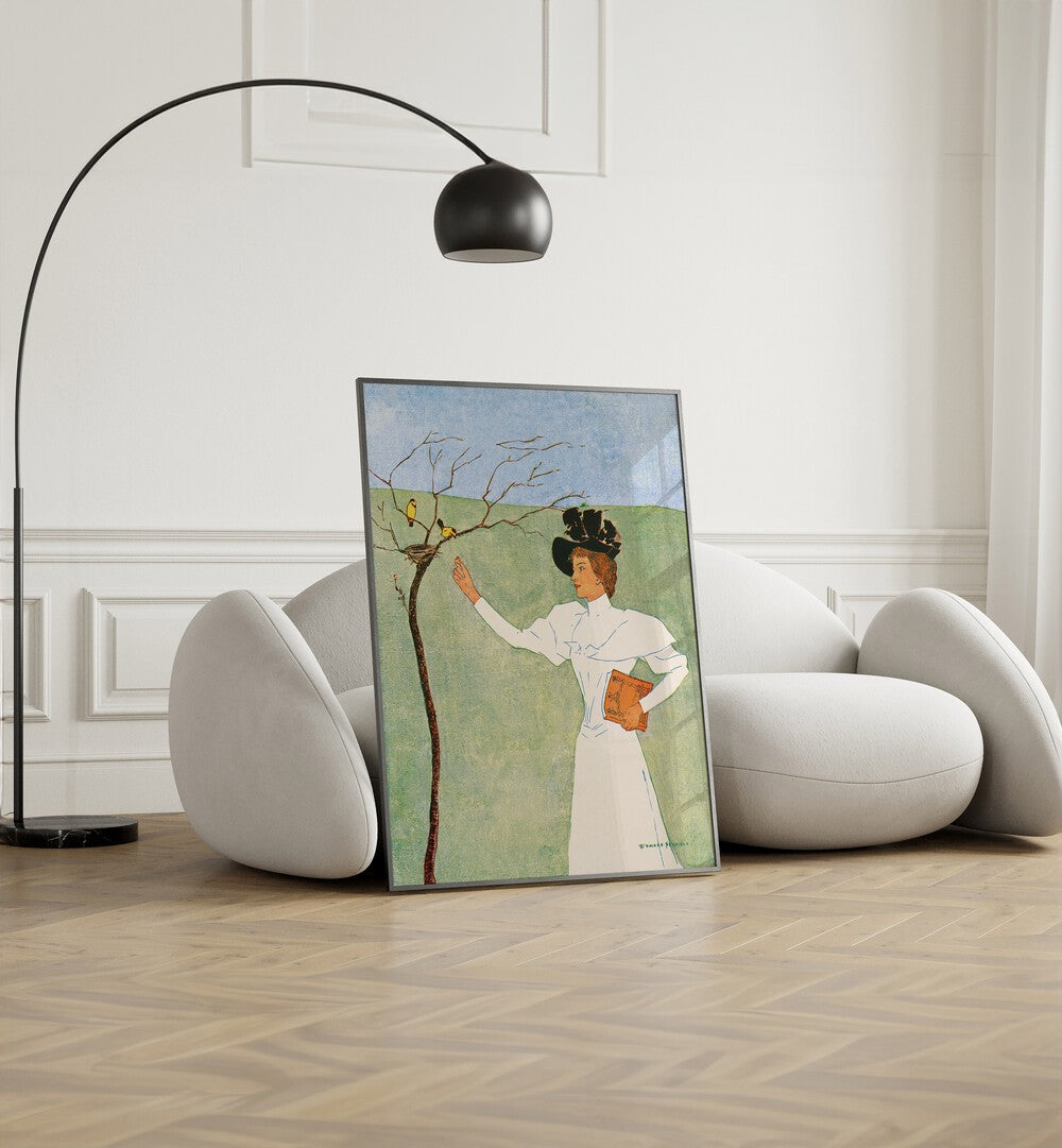 Woman Reaching For Birds 1894 Vintage Paintings in Black Plain Frame placed on the floor beside a sofa