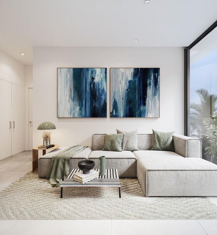 Elegant living room featuring the INDIGO SET, SET OF 2 PAINTINGS in deep blue and gray tones for a serene atmosphere.