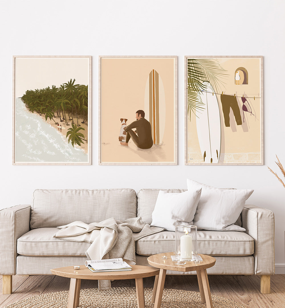 Living room with a beige sofa, coffee table, and wall art depicting a beach, a person with a dog, and a palm tree.
