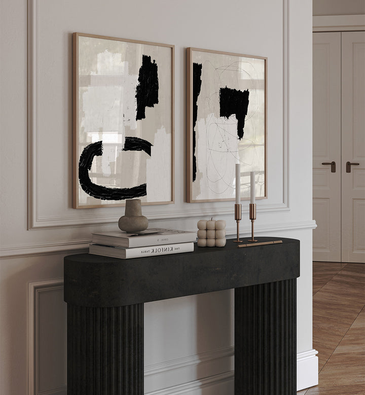 Two abstract art pieces on a wall above a fireplace with decorative items.