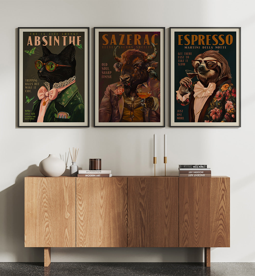 Three framed posters of animals with drinks above a wooden cabinet.