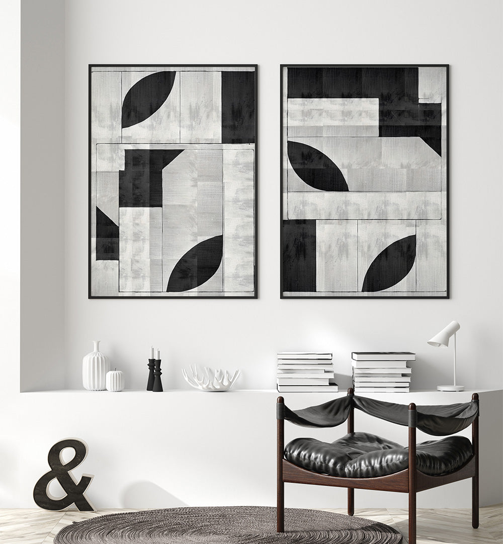 Modern interior with abstract black and white wall art, books, and a chair.