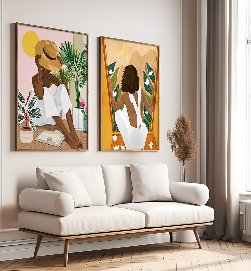 Two framed artworks of women in a modern living room with a white sofa.