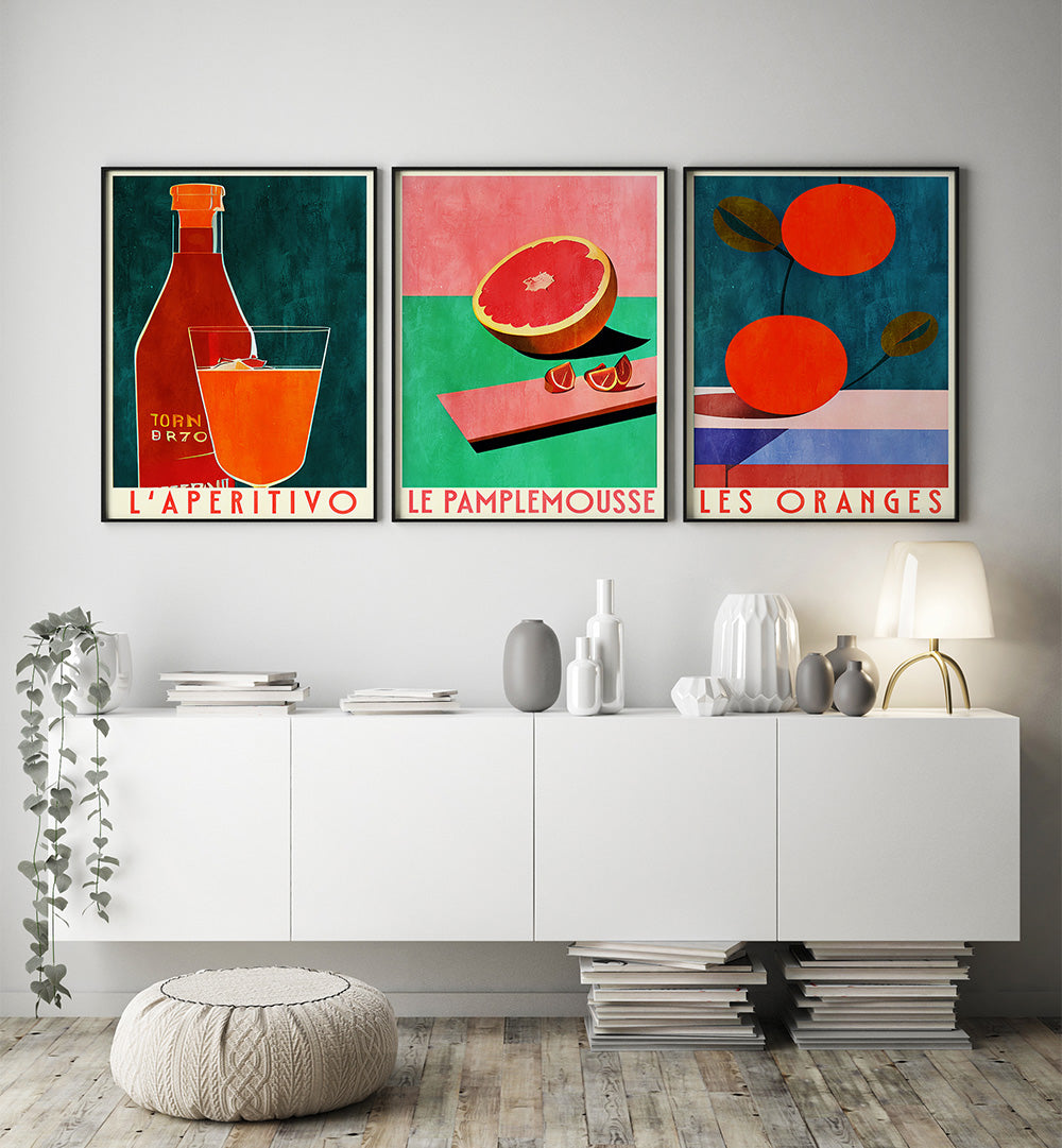 Three colorful art prints on a wall above a white cabinet.