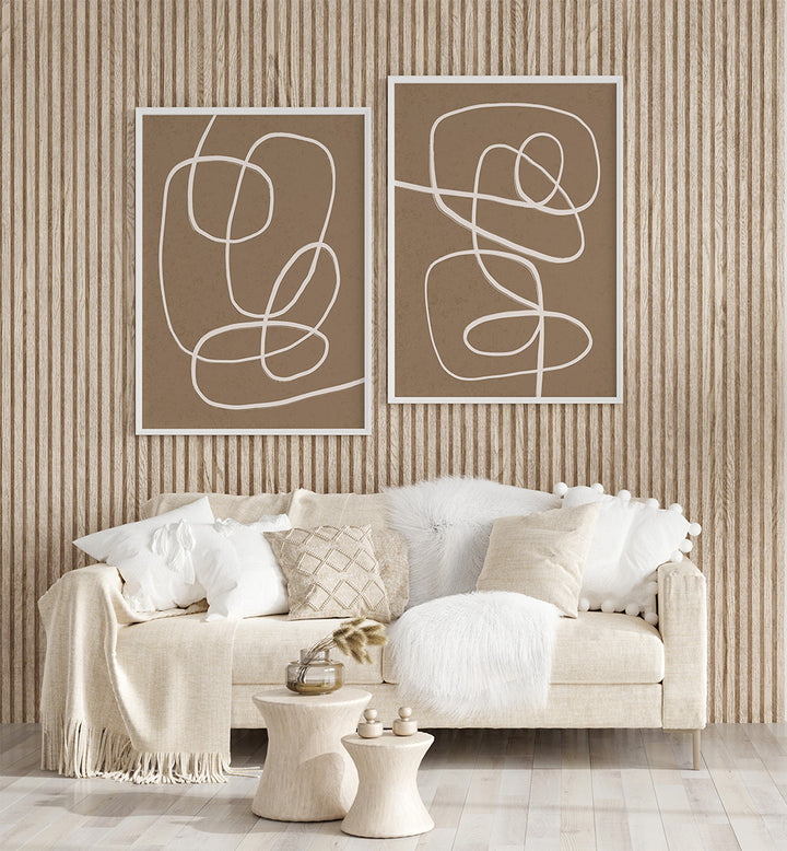 Beige sofa with decorative pillows against a wall with abstract line art.