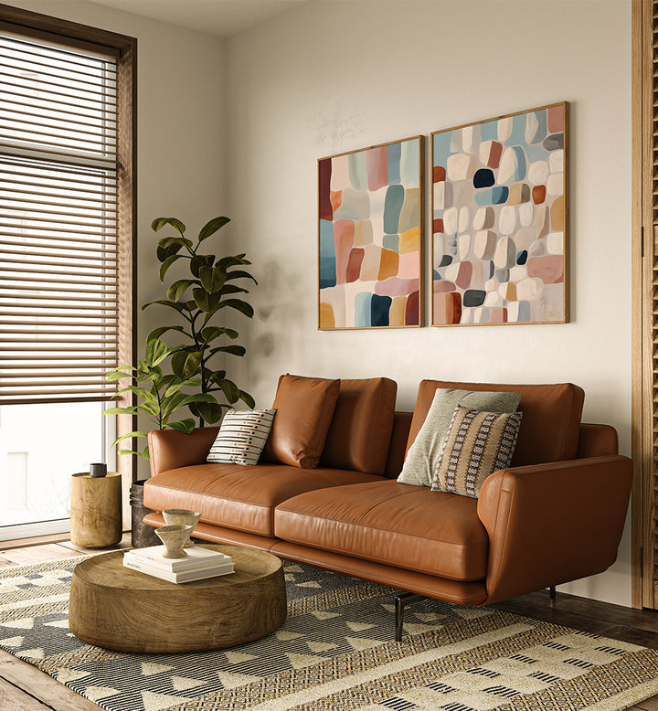 Modern living room with a brown leather sofa, wooden coffee table, and abstract wall art.