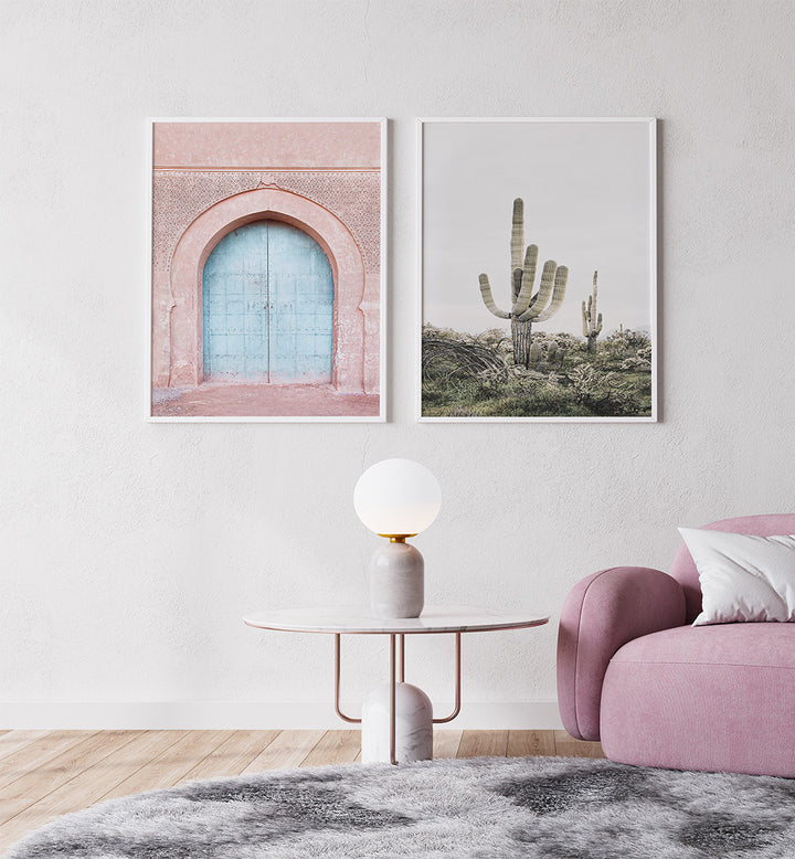Living room with pink armchair, round table, and two framed artworks on the wall.