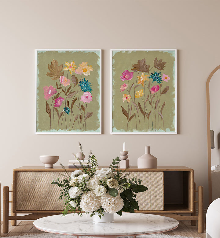Two floral paintings on a wall above a wooden console table with decorative items.