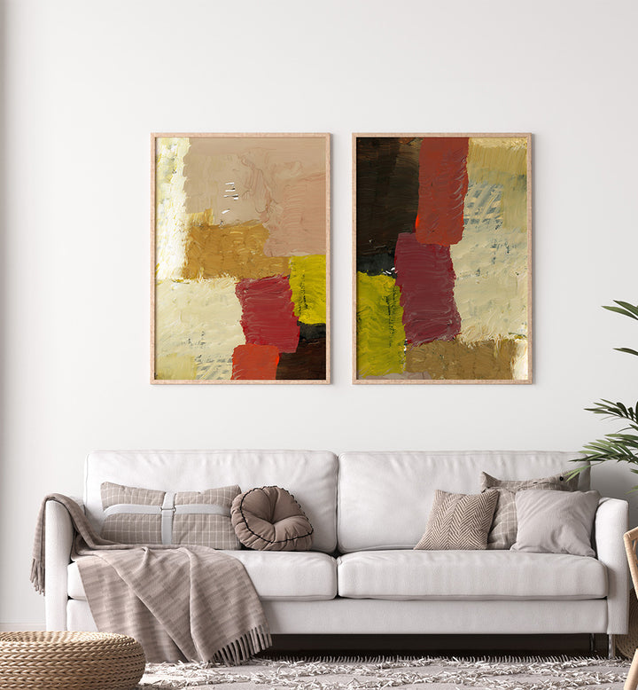 Two abstract paintings on a wall above a white sofa with decorative pillows.
