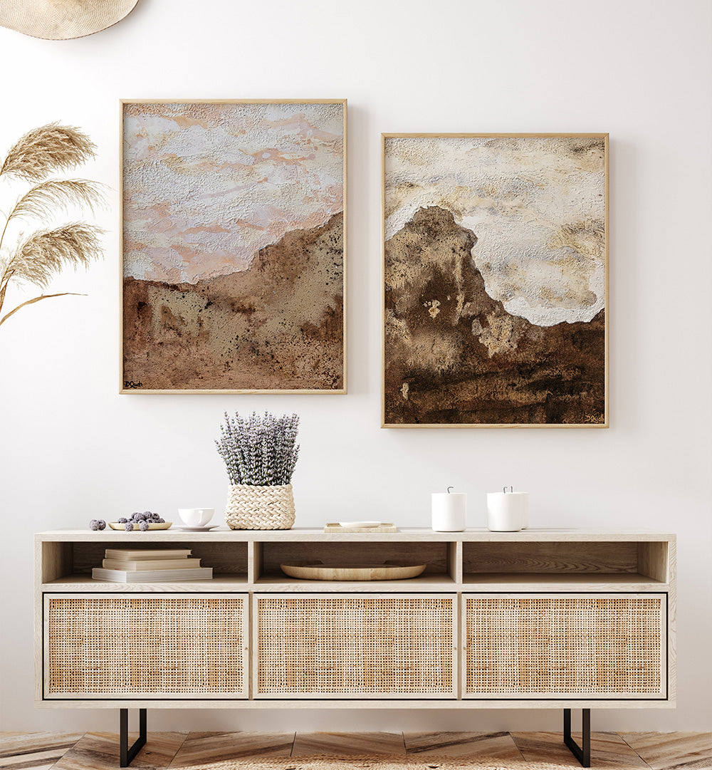 Two abstract paintings on a wall above a wooden console table with decorative items.