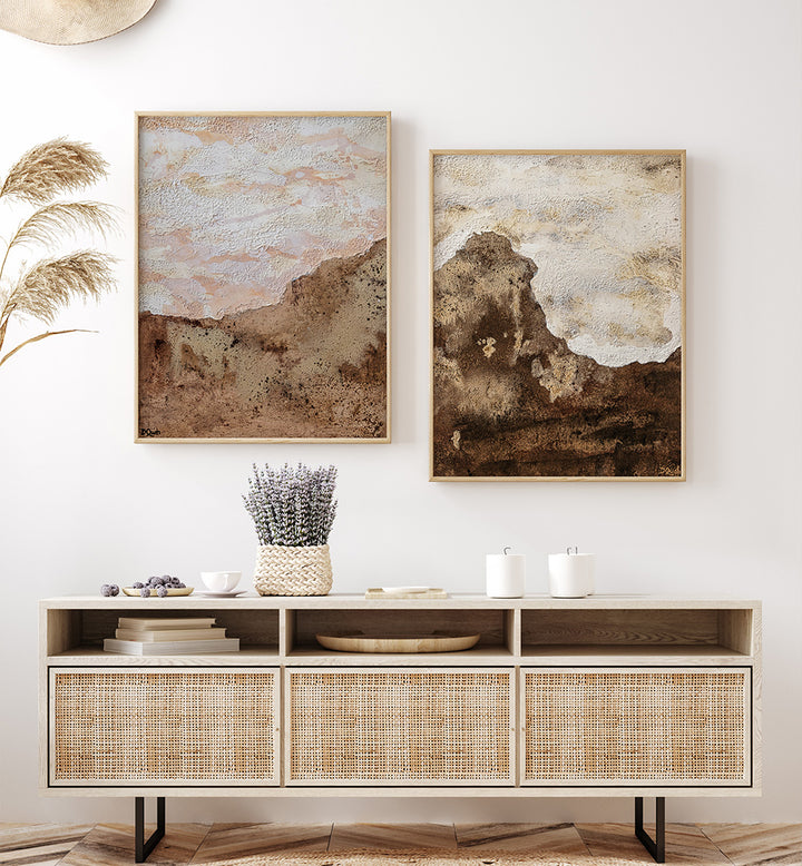 Two abstract paintings on a wall above a wooden console table with decorative items.