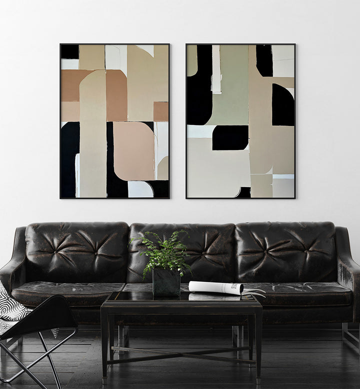 Two abstract art pieces hanging above a black leather sofa in a living room.