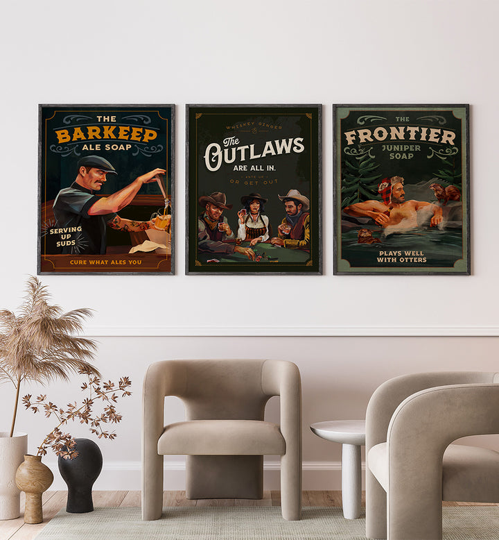 Three framed posters on a wall above a modern living room setup.