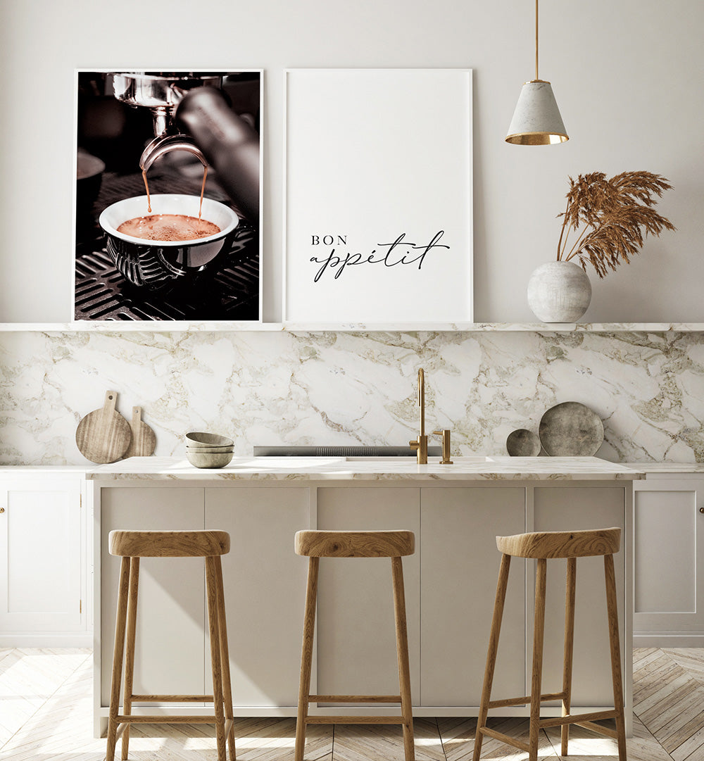 Modern kitchen with marble backsplash, wooden stools, and framed art on the wall.