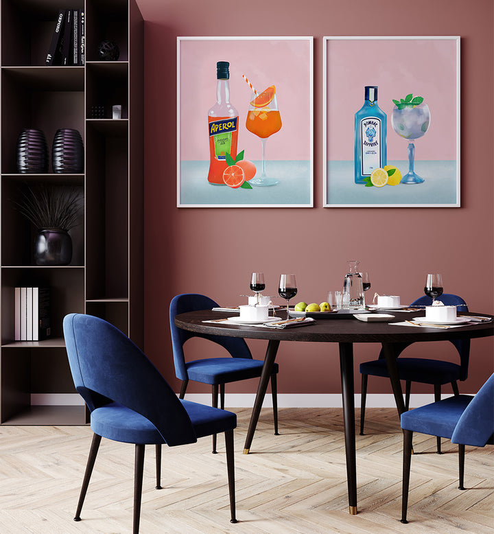 Dining room with blue chairs, a round table, and two framed cocktail posters on a pink wall.
