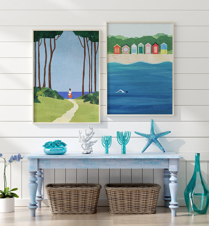 Two framed artworks on a wall above a table with decorative items.