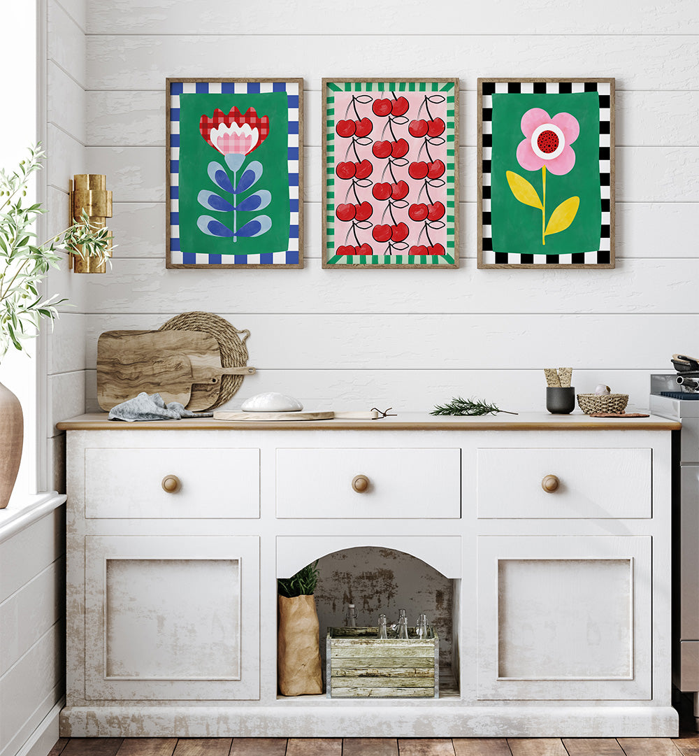 Kitchen with white cabinets, wooden countertop, and colorful floral and fruit-themed wall art.