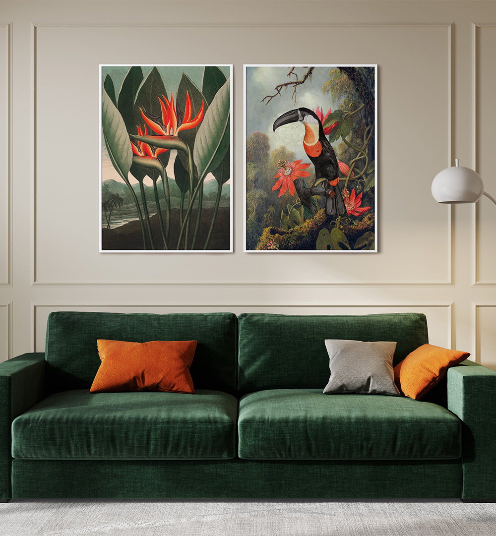 Two framed artworks of a toucan and red flowers above a green sofa with colorful cushions.