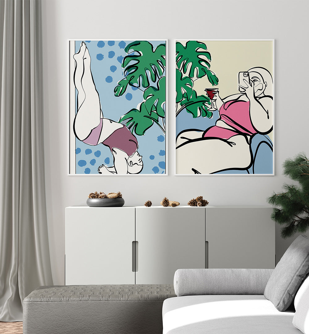 Two abstract art prints on a wall above a white cabinet with decorative items.