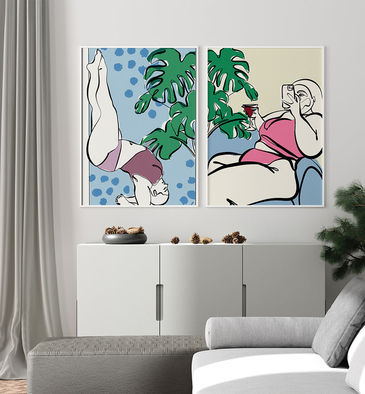 Two abstract art prints on a wall above a white cabinet with decorative items.