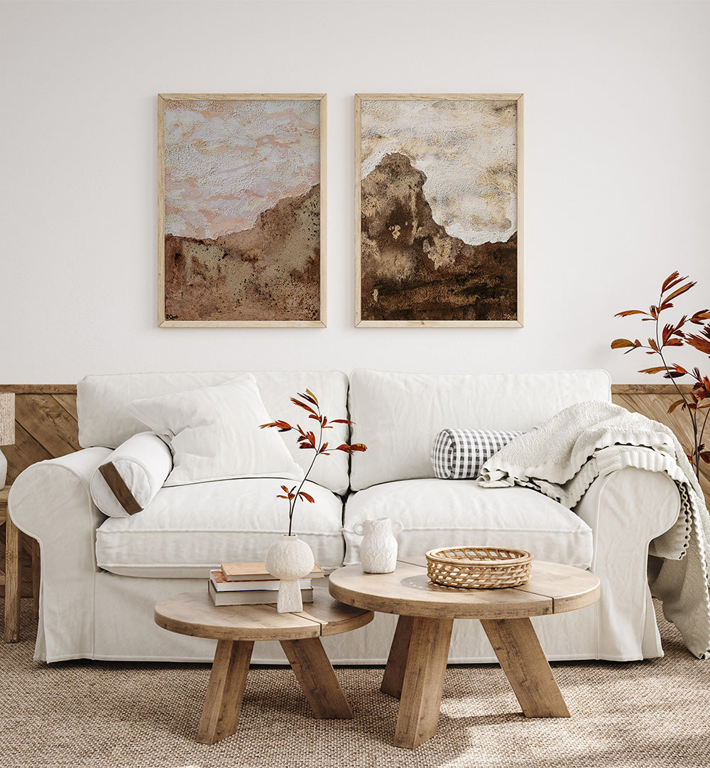 Living room with a white sofa, wooden coffee tables, and framed artwork on the wall.
