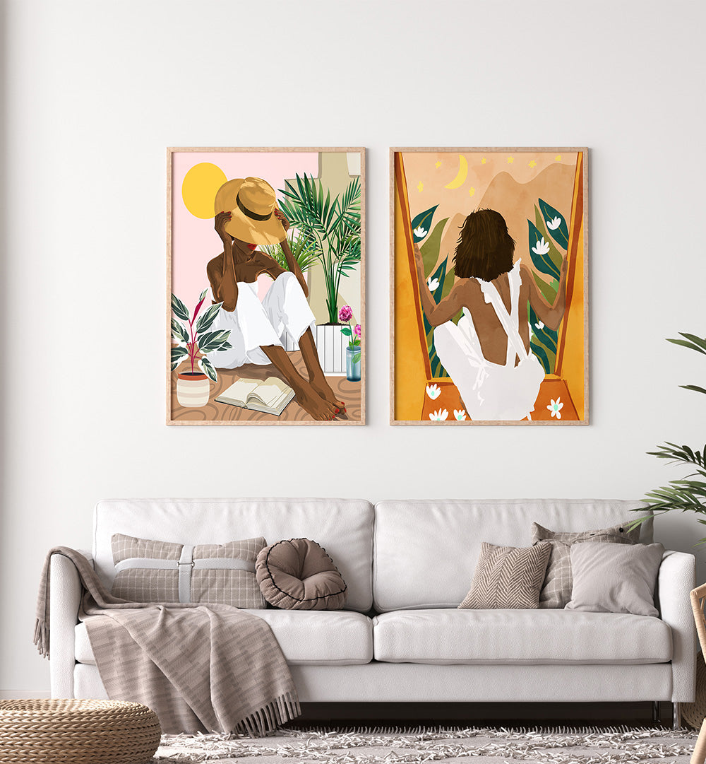 Two framed artworks of women in a living room setting with a white sofa and decorative pillows.