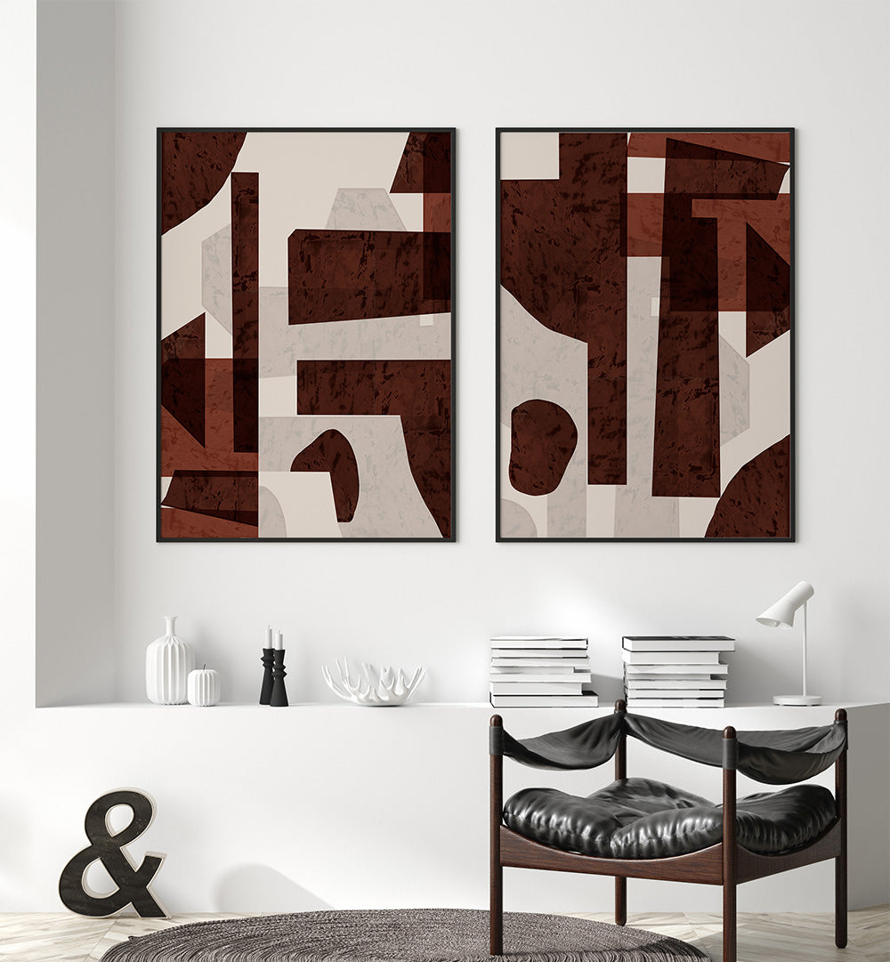 Two abstract art pieces hanging on a wall above a dining table.