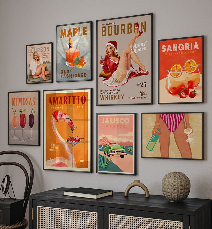 Collection of framed cocktail posters on a wall above a black cabinet.