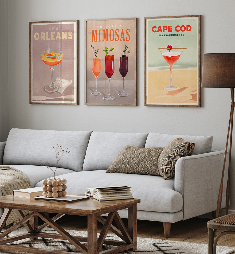Living room with a gray sofa, wooden coffee table, and wall art featuring cocktail-themed prints.