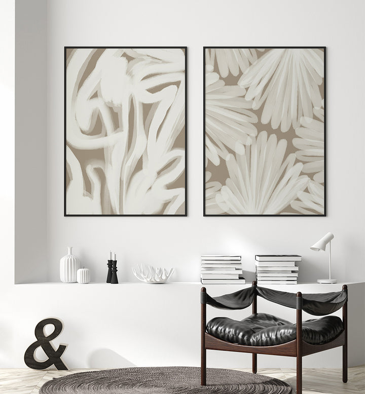 Two abstract wall art pieces on a white wall above a console table with decor items.