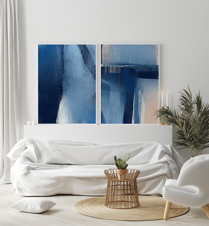 Modern living room with abstract blue artwork on a white wall, white sofa, and decorative items.