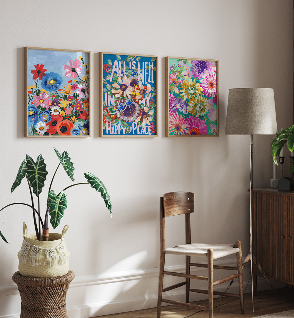 Decorative wall art with floral designs and motivational quote in a room with a chair, lamp, and plant.