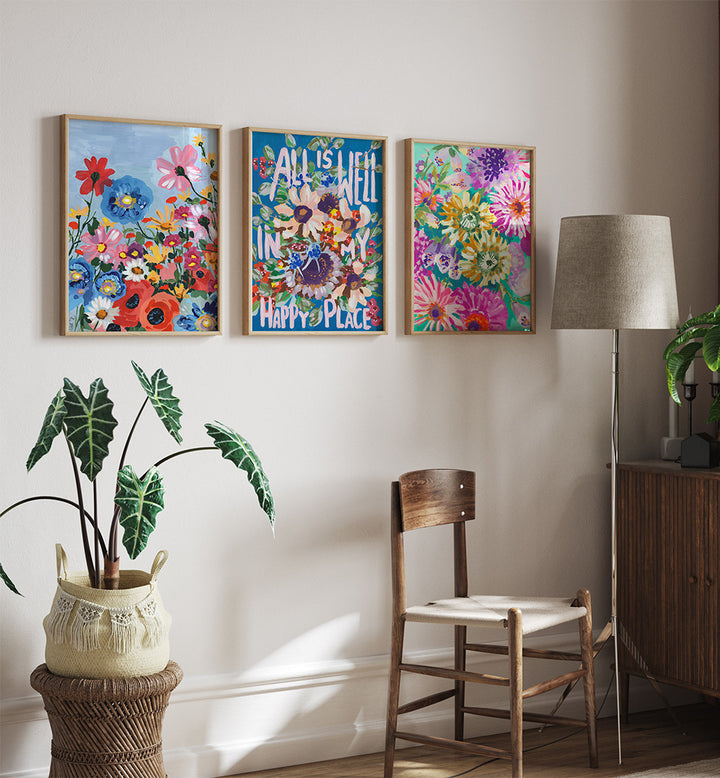 Decorative wall art with floral designs and motivational quote in a room with a chair, lamp, and plant.