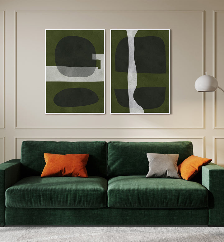 Green sofa with orange and gray cushions in front of abstract wall art