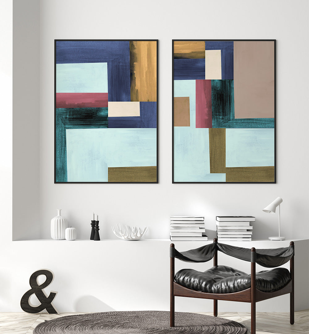 Two abstract art pieces hanging on a wall above a dining table.