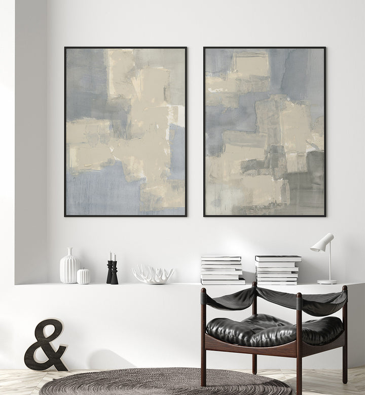 Two abstract art pieces on a wall above a white fireplace with decorative items.