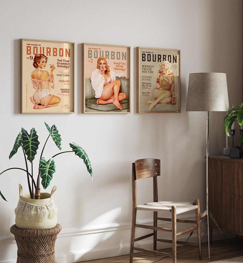 Three vintage-style Bourbon posters on a wall with a chair, lamp, and plants in the foreground.