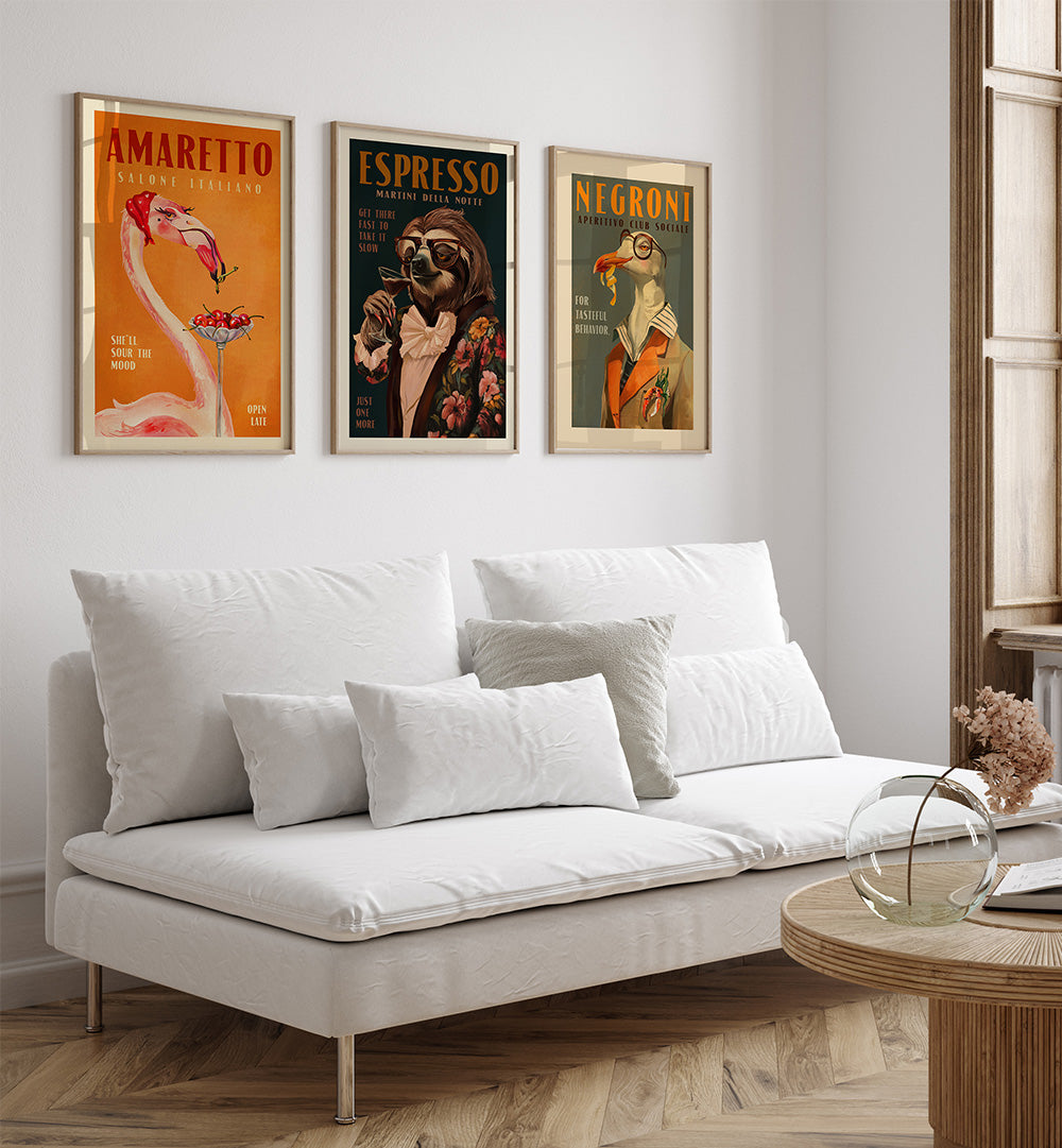 White sofa in a living room with three framed posters on the wall.