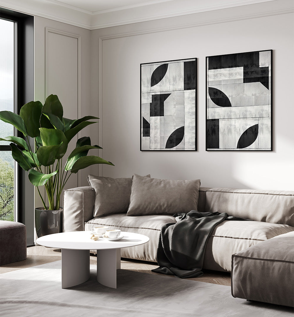 Modern living room with a gray sectional sofa, round coffee table, and abstract wall art.