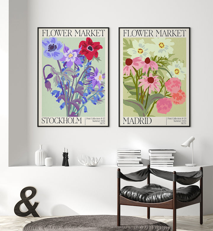 Two floral-themed posters titled 'Flower Market Stockholm' and 'Flower Market Madrid' on a wall above a table with books.