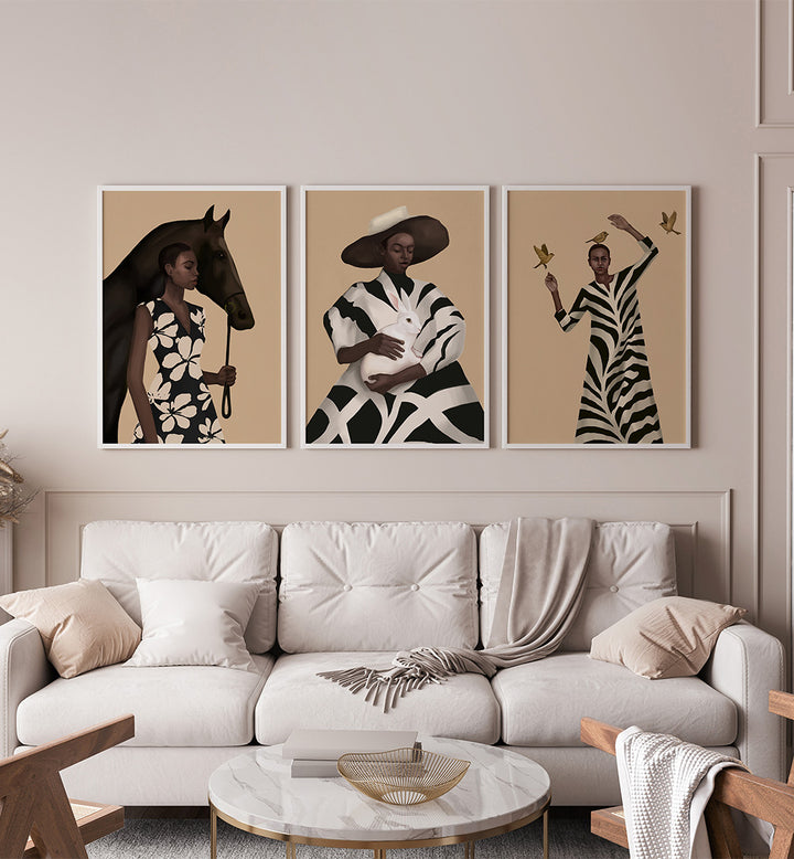 Three framed artworks above a white sofa in a living room setting.