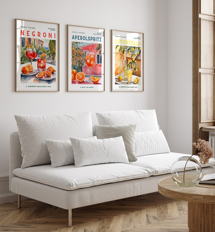 White sofa in a living room with three framed cocktail posters on the wall.